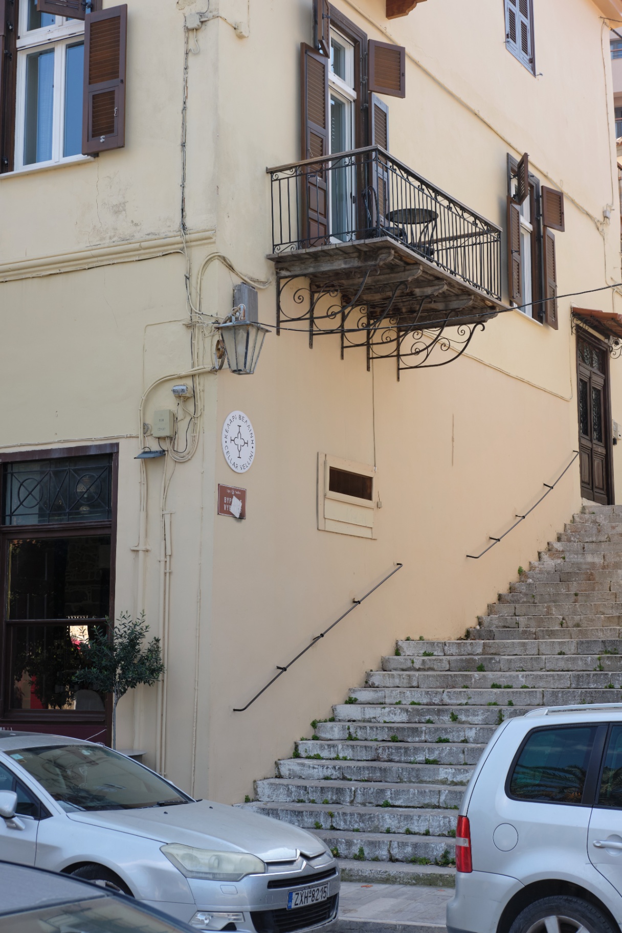 The neoclassical facade of Nafpliou Chora with its wrought-iron balcony above the old-town steps.