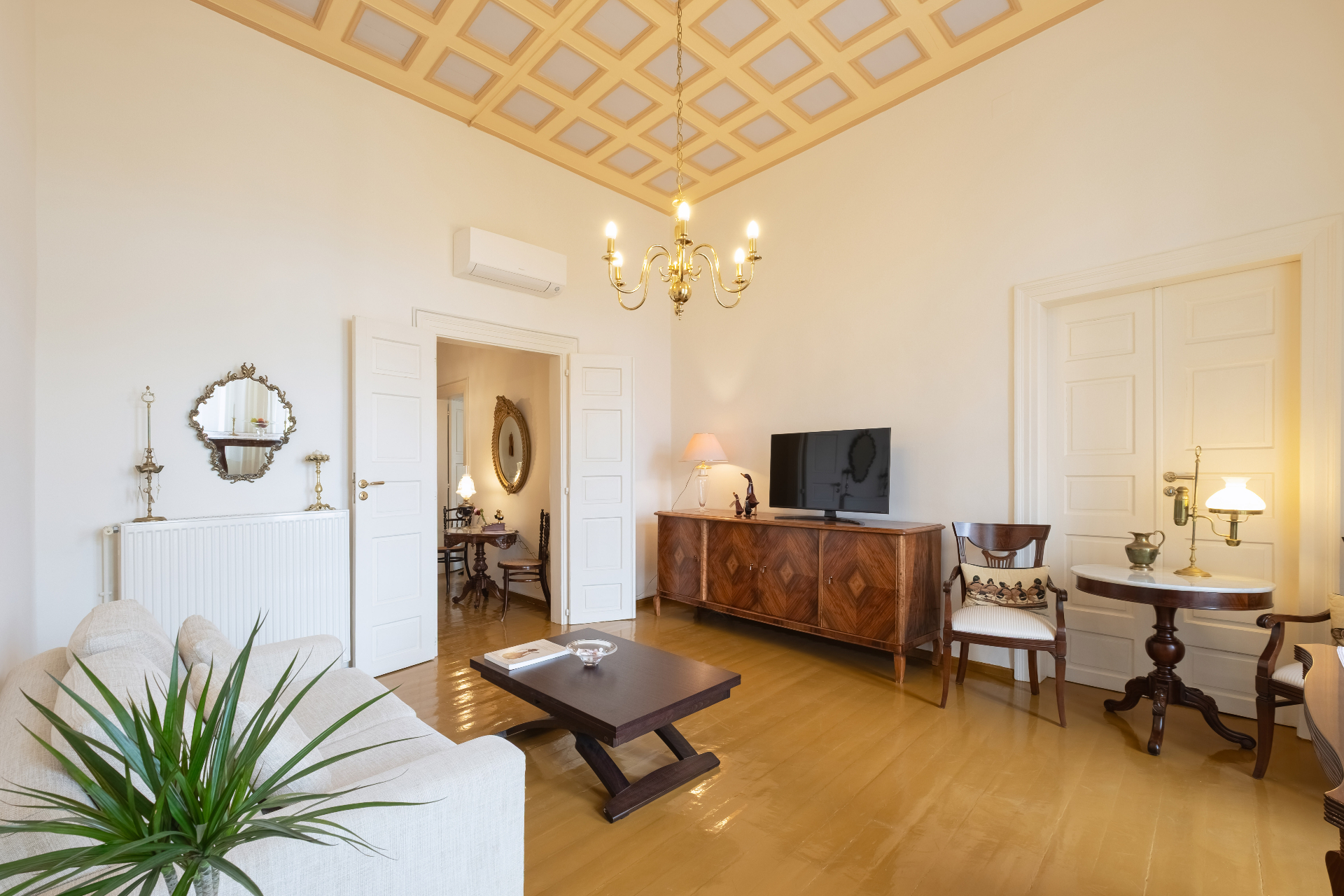 Living room view showing antique furniture and polished wooden floors.